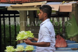 SRI LANKA, Kandy, Temple of the Tooth (Dalada Maligawa), man selling flowers for offerings, SLK3424JPL