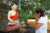 SRI LANKA, Kandy area, Degaldoruwa Cave Temple, Buddha statue, worshipper, SLK5783JPL