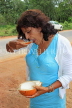 SRI LANKA, countryside, woman eating a king coconut (Thambili) kernel, SLK4571JPL