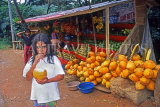SRI LANKA, roadside fruit stall, child drinking King Coconut water, SLK2126JPL