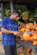 SRI LANKA, rural scene, roadside fruit stall, vendor cutting open a king coconut (Thambili), SLK4563JPL