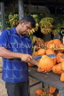 SRI LANKA, rural scene, roadside fruit stall, vendor cutting open a king coconut (Thambili), SLK4564JPL