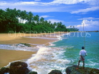 SRI LANKA, south coast, Gintota, beach, man fishing from rocks, SLK1376JPL