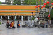 THAILAND, Bangkok, WAT SUTHAT, courtyard statues, and worshippers, THA3216JPL