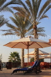 UAE, DUBAI, Madinat Jumeirah, poolside sunbeds and palm trees, UAE508JPL