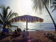 BARBADOS, West Coast beach, holidyamakers under sunshade, at dusk, BAR522JPL