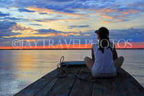 CAMBODIA, Tonle Sap Lake, tourist enjoying the sunset view from a tour boat, CAM934JPL