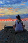 CAMBODIA, Tonle Sap Lake, tourist enjoying the sunset view from a tour boat, CAM935JPL