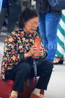 HONG KONG, Kowloon, Wong Tai Sin Temple, worshipper shaking Fortune Sticks, HK1163JPL
