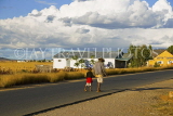 MADAGASCAR, Ilakaka, sapphire mine worker and child walking along road, MDG200JPL