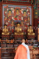 South Korea, SEOUL, Bongeunsa Temple, Daewoongjeon hall, wooden Buddhas and monk, SK848JPL