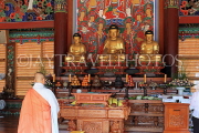 South Korea, SEOUL, Bongeunsa Temple, Daewoongjeon hall, wooden Buddhas and monk, SK850JPL