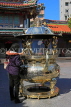 Taiwan, TAIPEI, Lungshan Temple, worshipper by incense burner censer, TAW659JPL